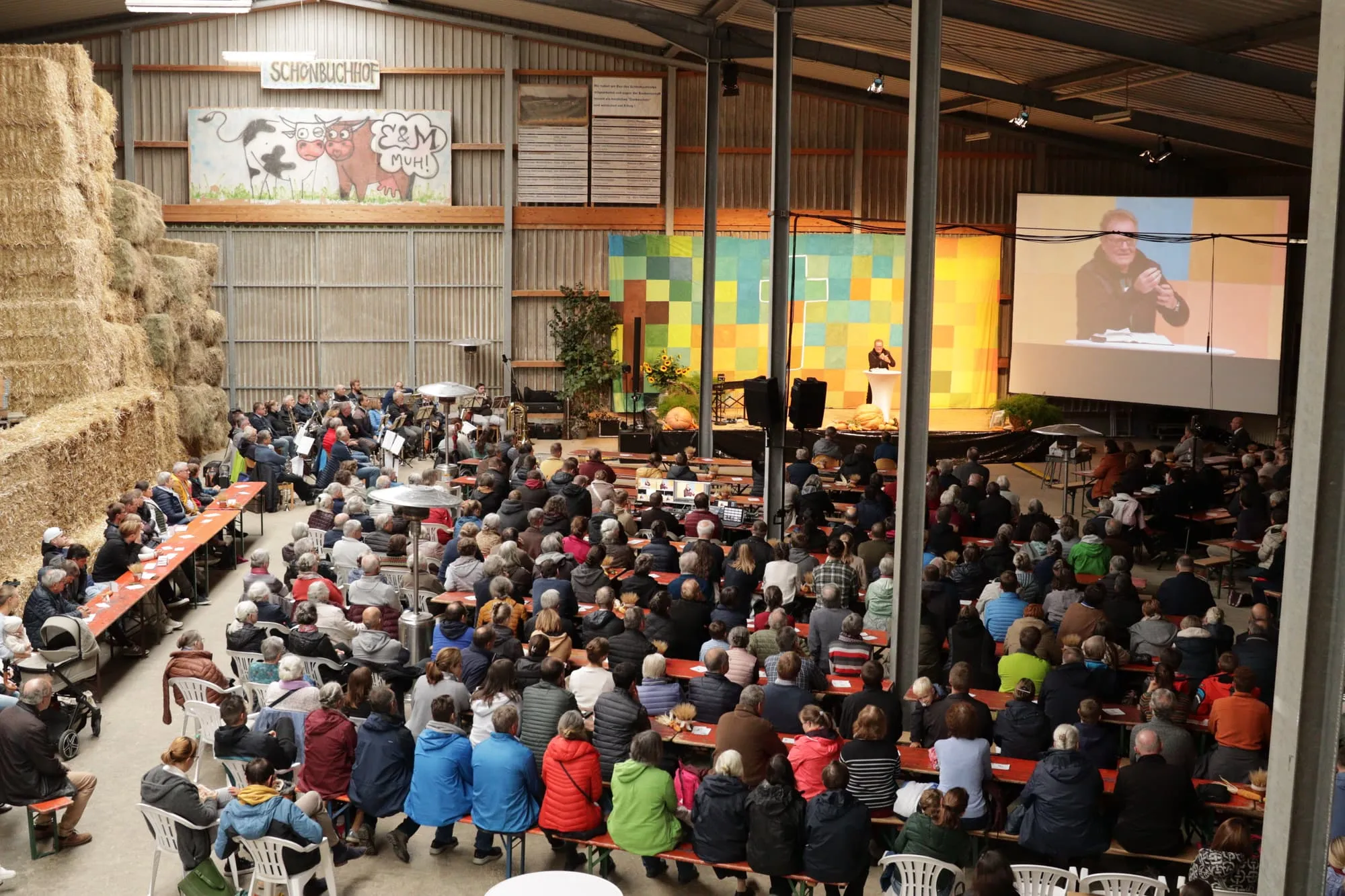 Der Missionstag in der Halle des Schönbuchhofs: die Reihen sind bis nach hinten besetzt, vorne die Bühne mit Leinwand.