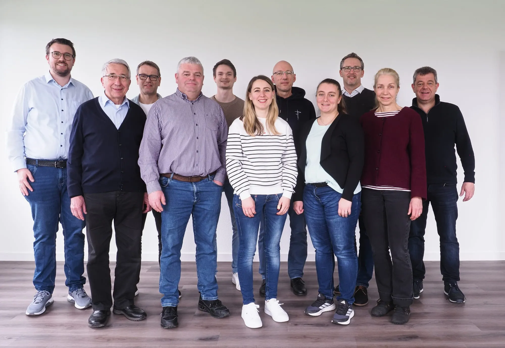 Der Mitarbeiterkreis von Christen helfen Christen steht nebeneinander in einem hellen Raum.